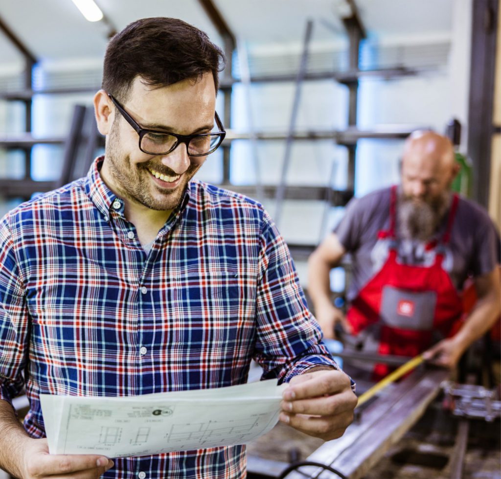 Man with glasses looking at construction documents