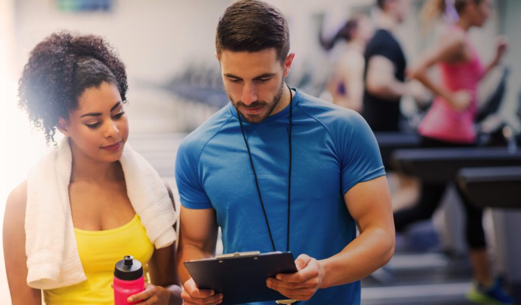 Two people at the gym looking at a clipboard